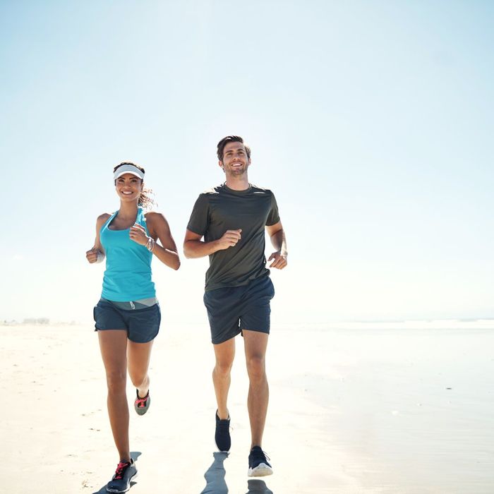 man and woman running on beach