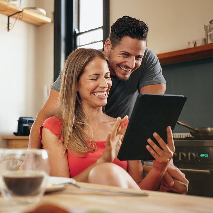 smiling couple looking at a tablet