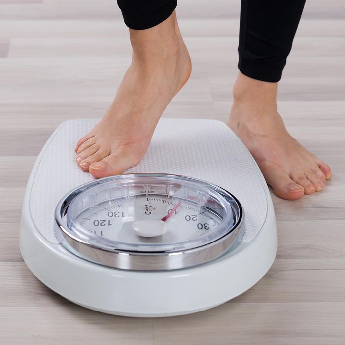 woman stepping on a scale