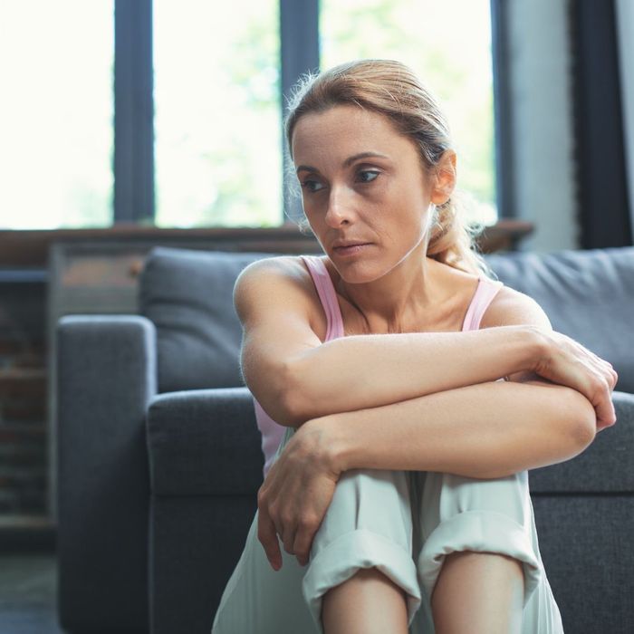 Person sitting on the floor staring off to the side