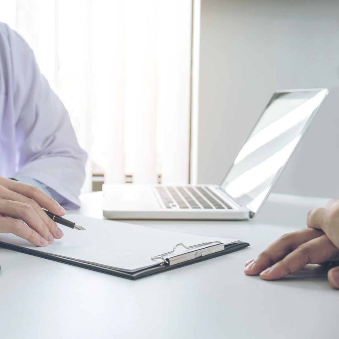 a doctor taking notes and talking with a patient