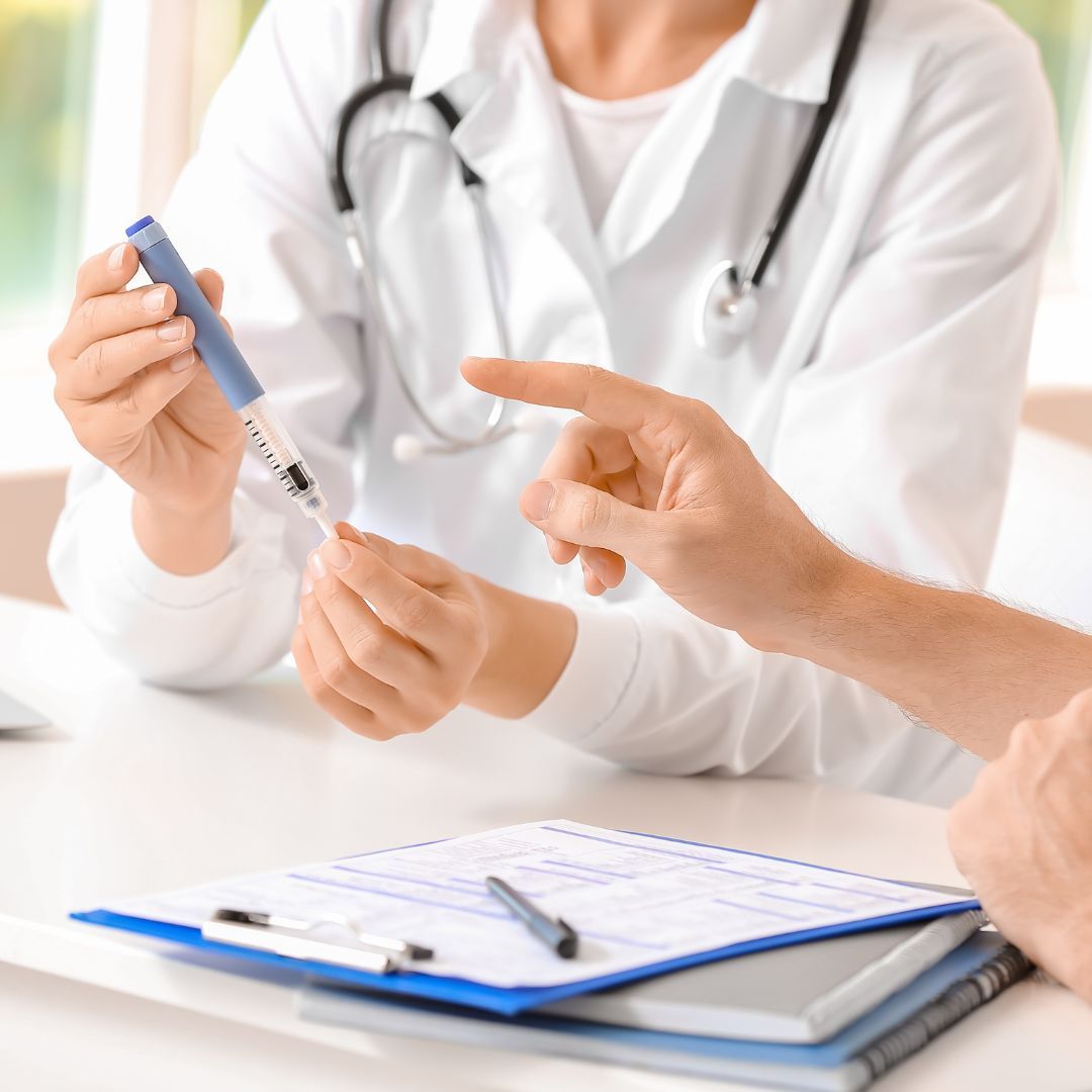 a doctor holding a syringe and talking with a patient