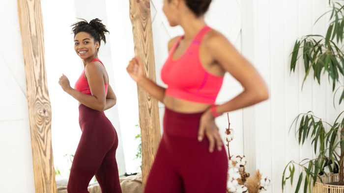 person looking in mirror wearing fitness outfit