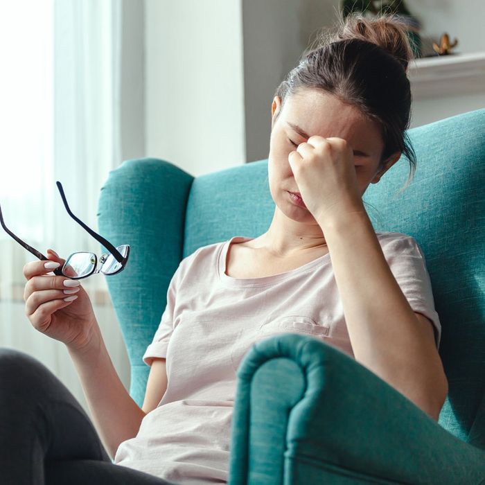 Women holding her eyes representing a headache 