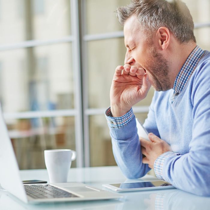 Person yawning while using a laptop