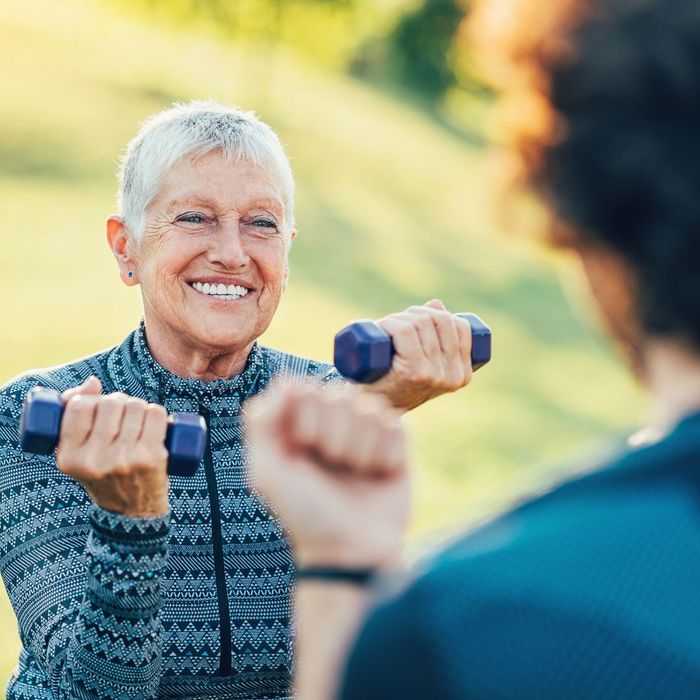 smiling elderly woman lifting weights