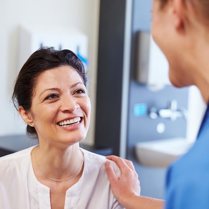 smiling woman talking to her healthcare provider