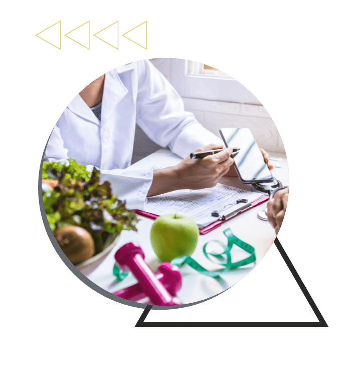 a doctor pointing at a phone, sitting at a desk with healthy foods, weights, and a chart on it