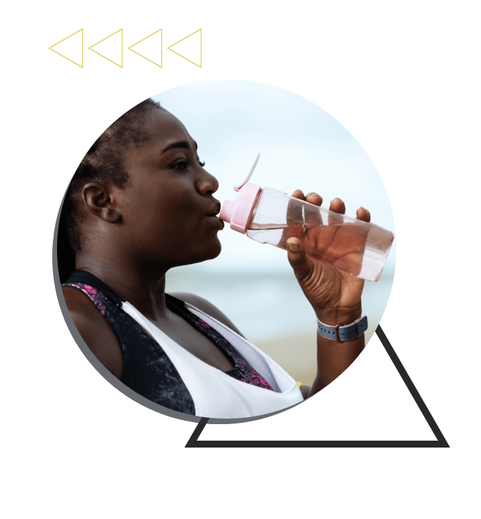 a woman in workout clothes drinking water