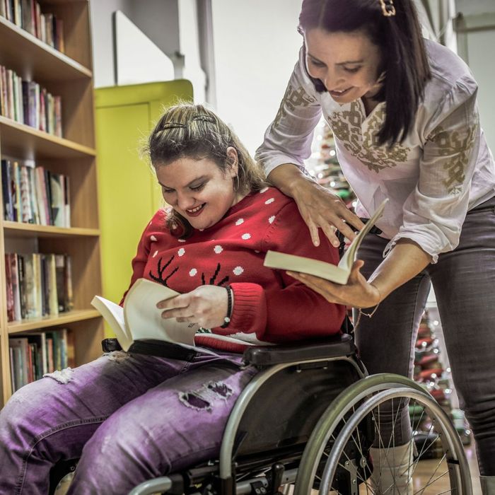 special needs caregiver and client reading books