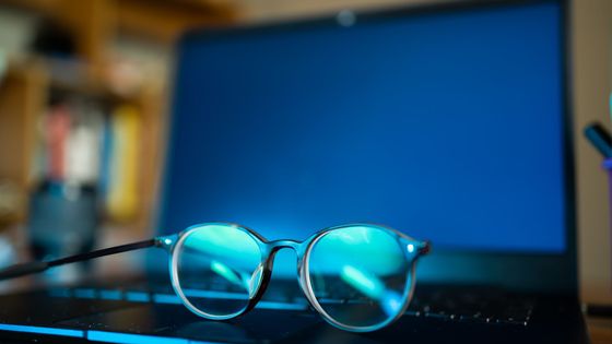 Glasses resting next to a laptop