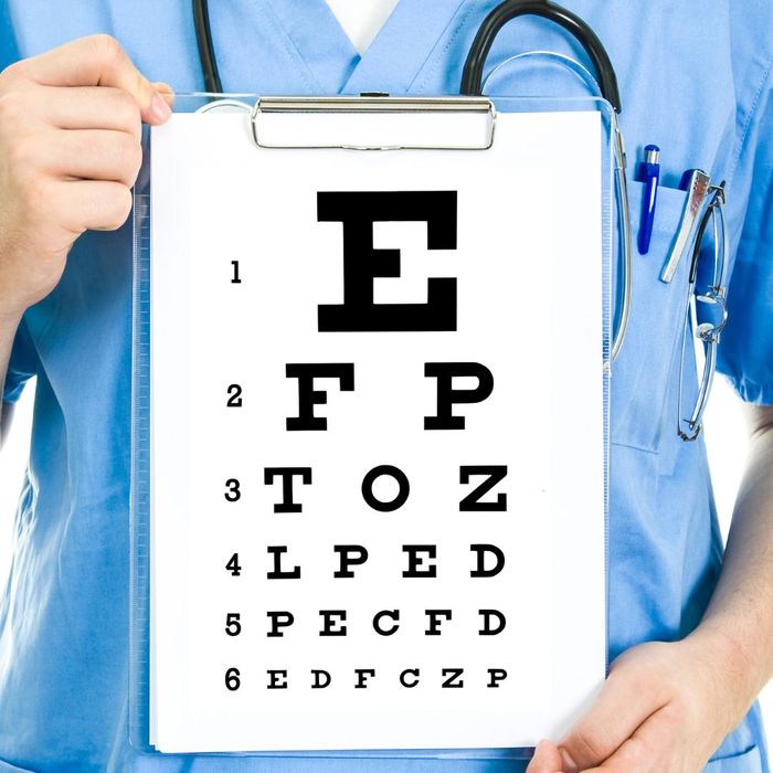A doctor holding up a board with letters to see how far you can read