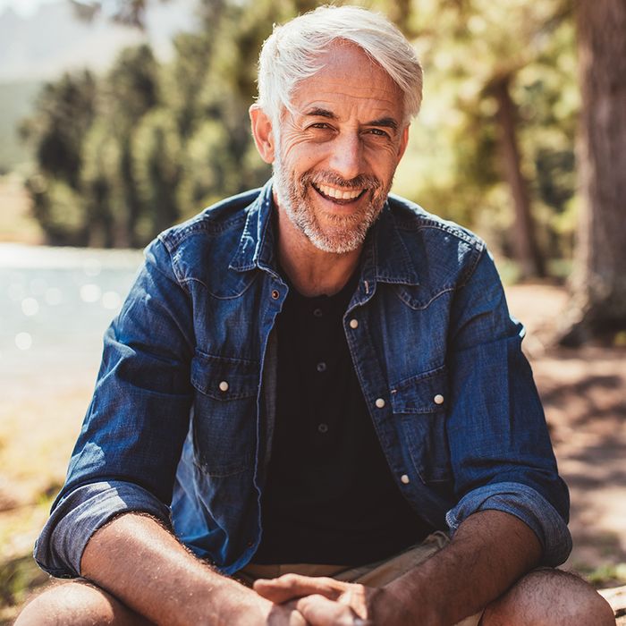 older man smiling outside