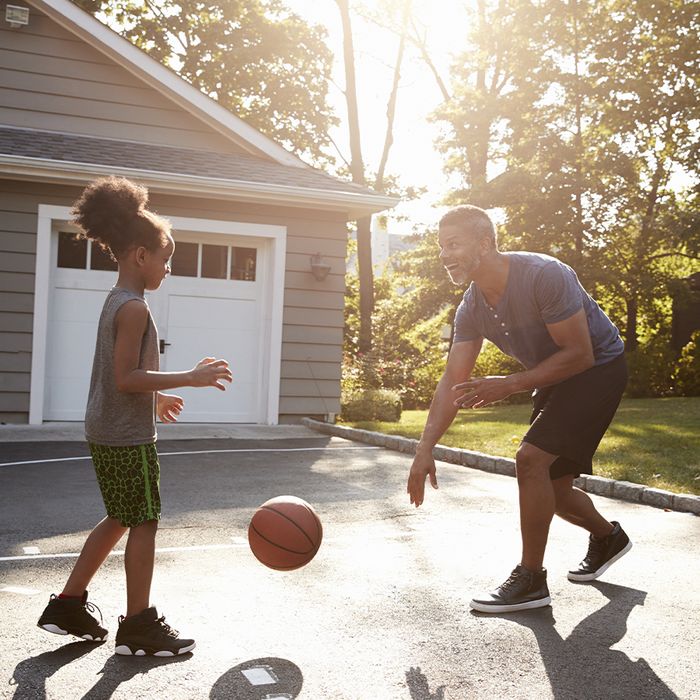 father playing basketball with daughter