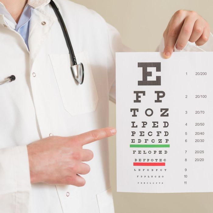 A doctor holding a sign to test your vision ability