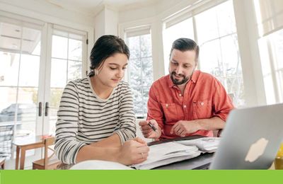 father helping teenage daughter with homework