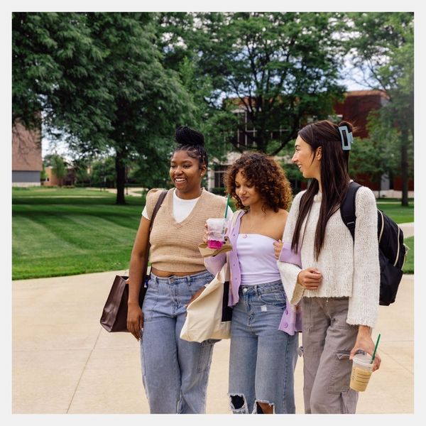 3 teenage girls walking outside on campus