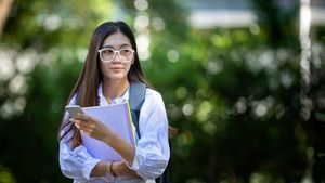 college girl walking outside with backpack