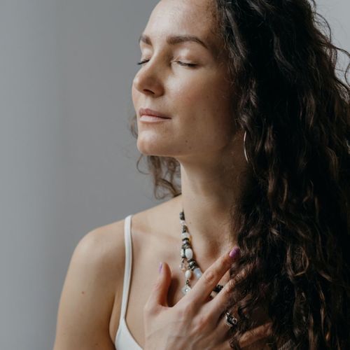 woman taking deep breath with hands on chest