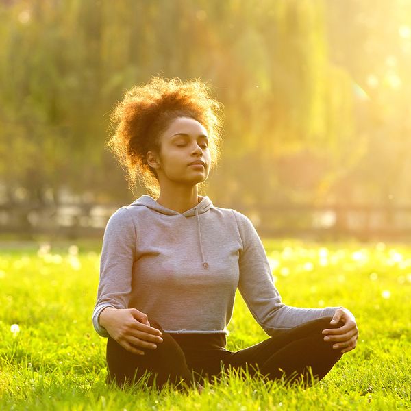 Person sitting calmly, observing thoughts passing overhead like clouds. meditating.jpg