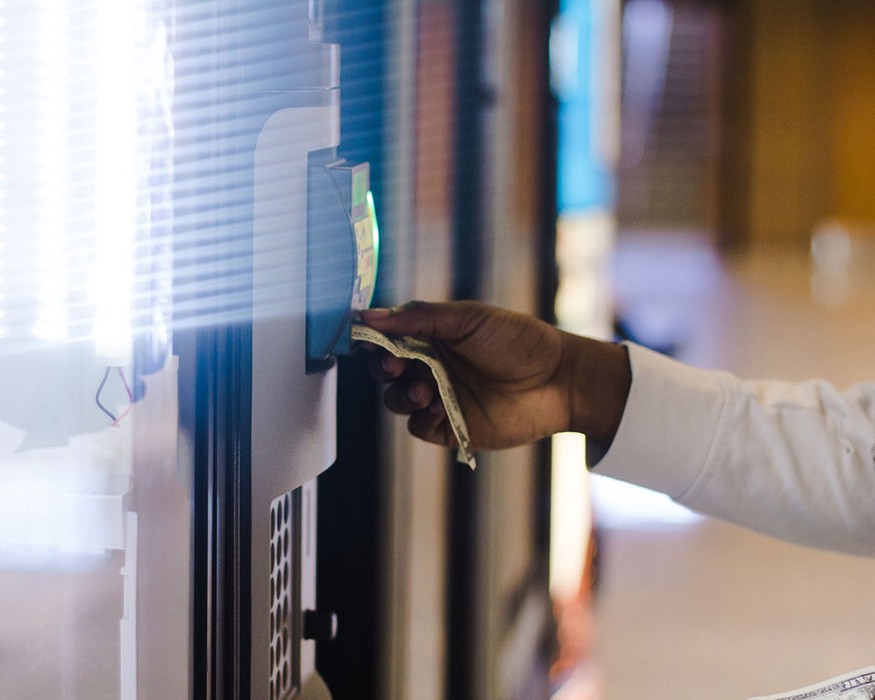 man putting dollar into vending machine