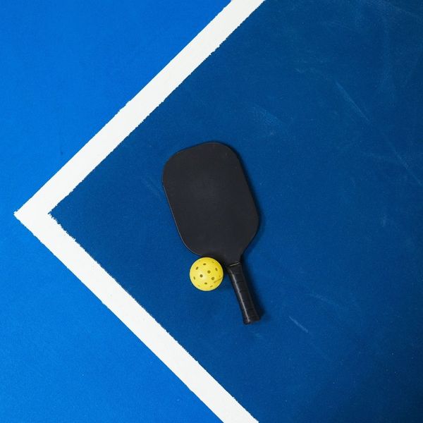 Pickleball paddle resting on court