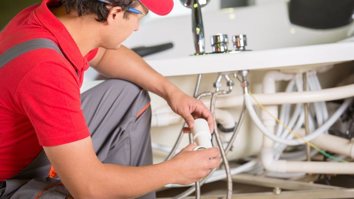 Professional plumber replacing plumbing components. 