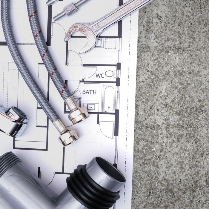 Blueprint with plumbing parts on it. 