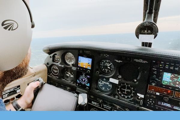 View from the cockpit showing the pilot's perspective of the instrument panel, featuring a mix of analog gauges and a modern glass cockpit display.