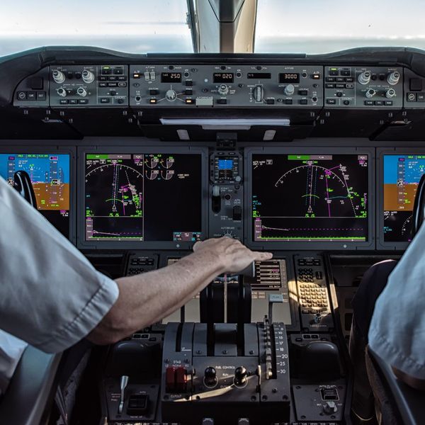 Pilots operating in a plane's cockpit. Pilots operating in a plane's cockpit.