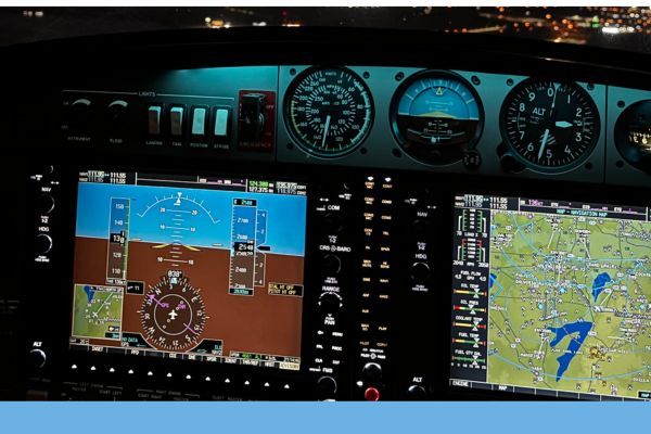 A close-up view of a Cockpit panel at night, showing Primary Flight Display (PFD) and Multi-Function Display (MFD) screens.