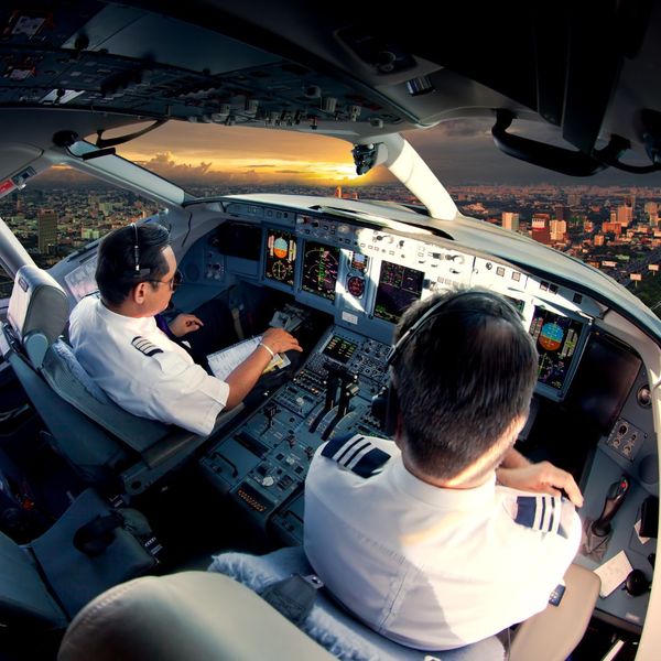 Two pilots flying over a city