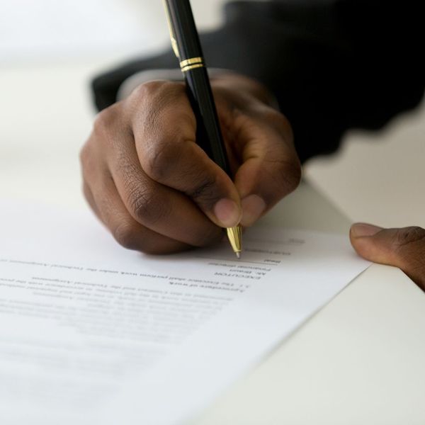 close up of hand signing legal document