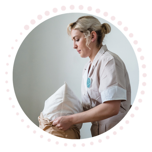 Maid putting a pillow in a pillow case