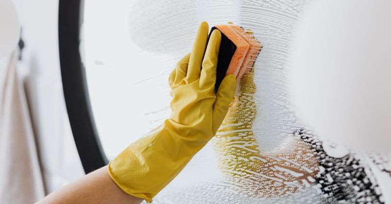 cleaning a mirror in a home