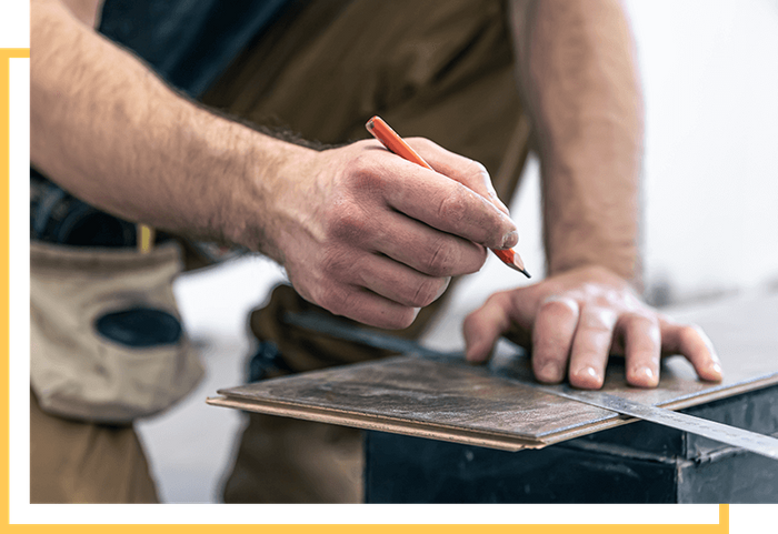 image of a man measuring a wood plank