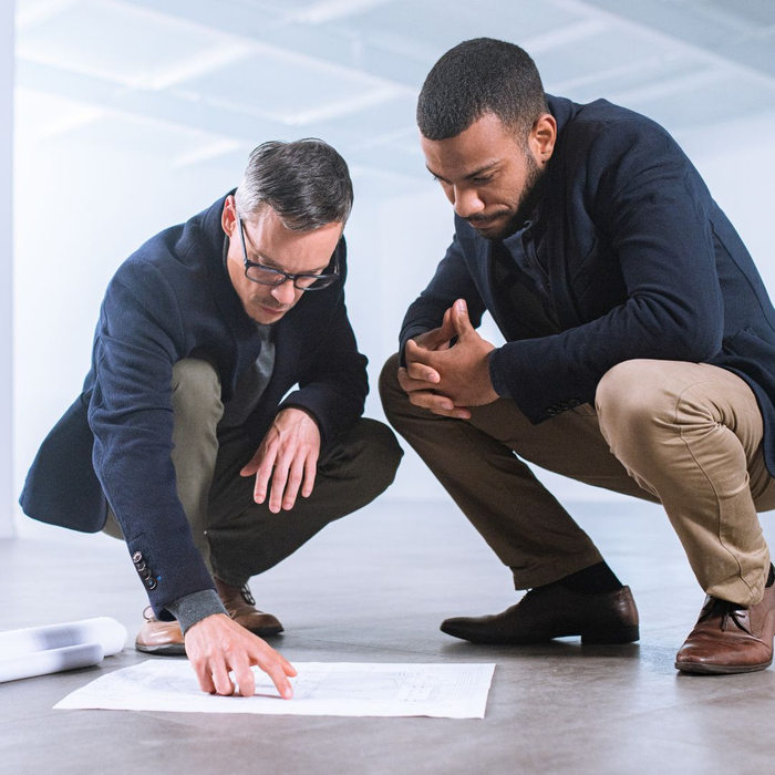 men examining floor plan