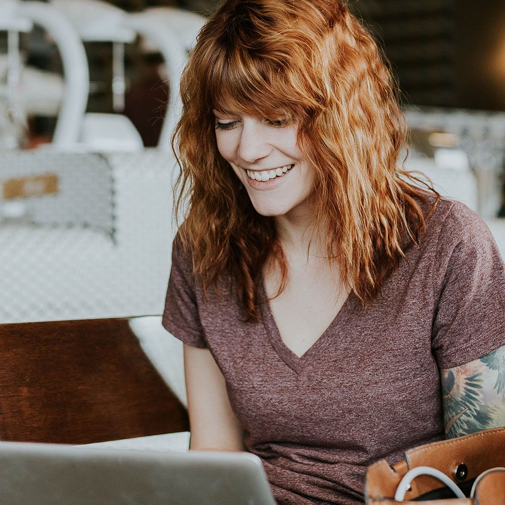 Woman working on laptop smiling 