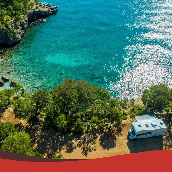 aerial view of RV parked next to crystal clear lake
