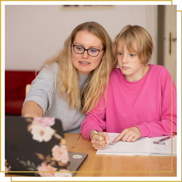 mother working on computer with high school daughter