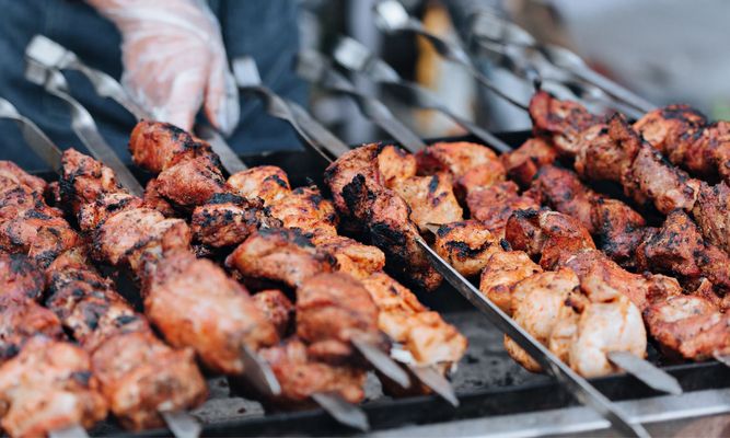 multiple skewers of chicken on a grill