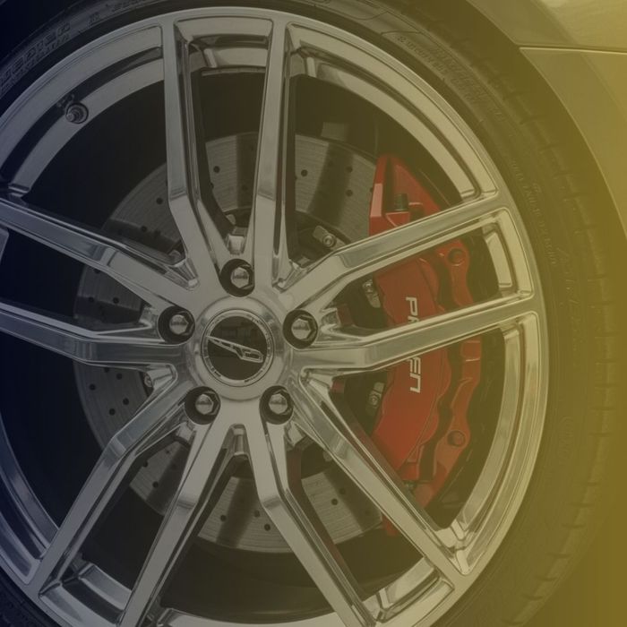 a professionally cleaned and detailed alloy wheel and brake caliper on a luxury car