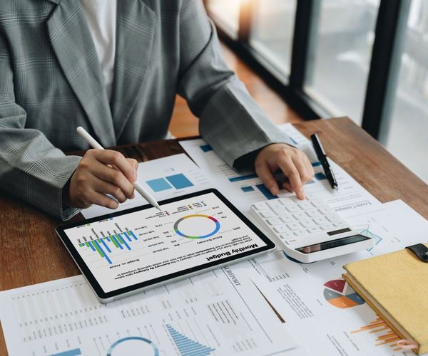 A person performing expert bookkeeping tasks with a tablet and organized financial documents, representing reliable financial management for Hawaii businesses.