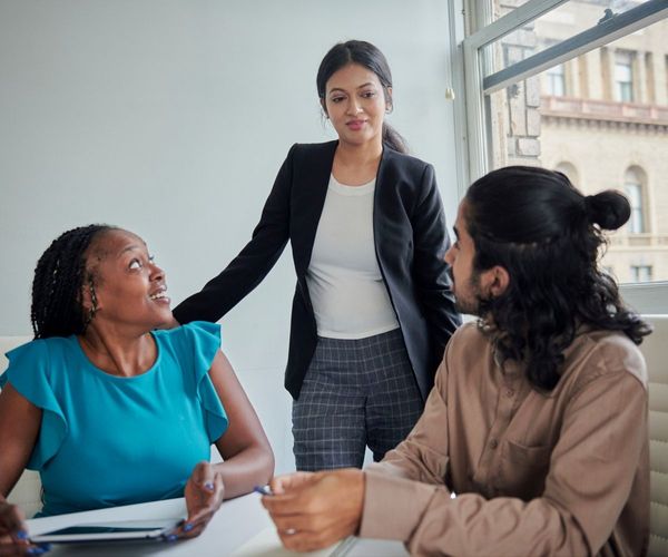 A leadership team collaborating in a bright workspace, illustrating effective team communication and cultural transformation strategies.