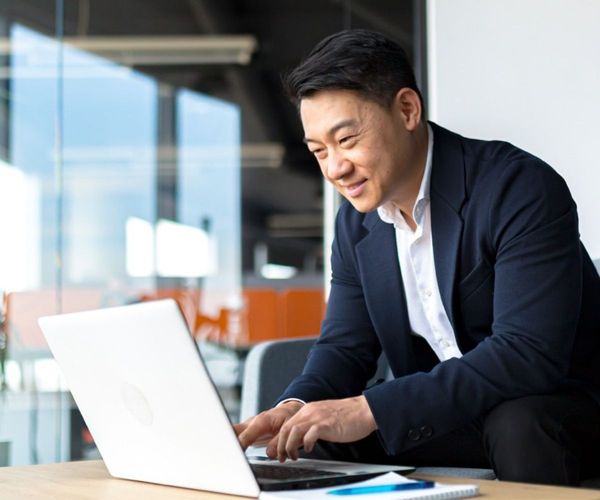 Business owner happily working on his laptop in an office