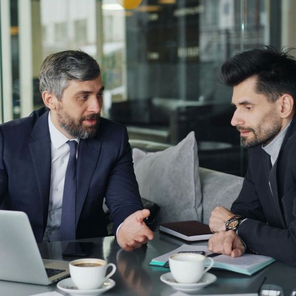 two business men talking with one stressed out two business men talking with one stressed out