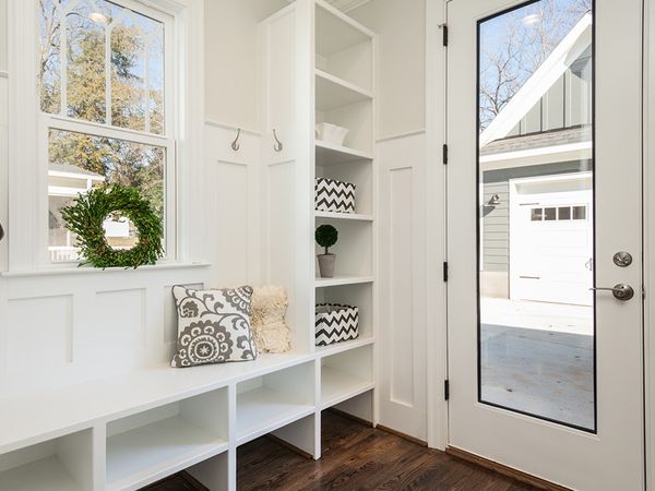 An entry way with a bench and nice white door with a large glass panel