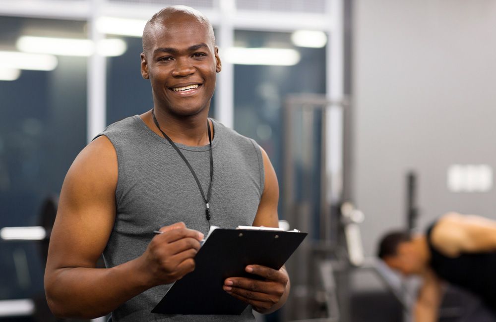 Smiling personal trainer with a clipboard