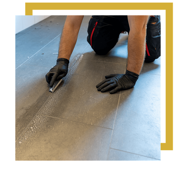 man cleaning grout lines