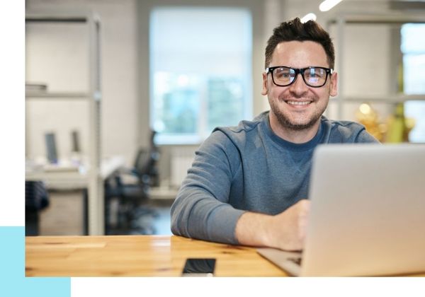 smiling man using laptop